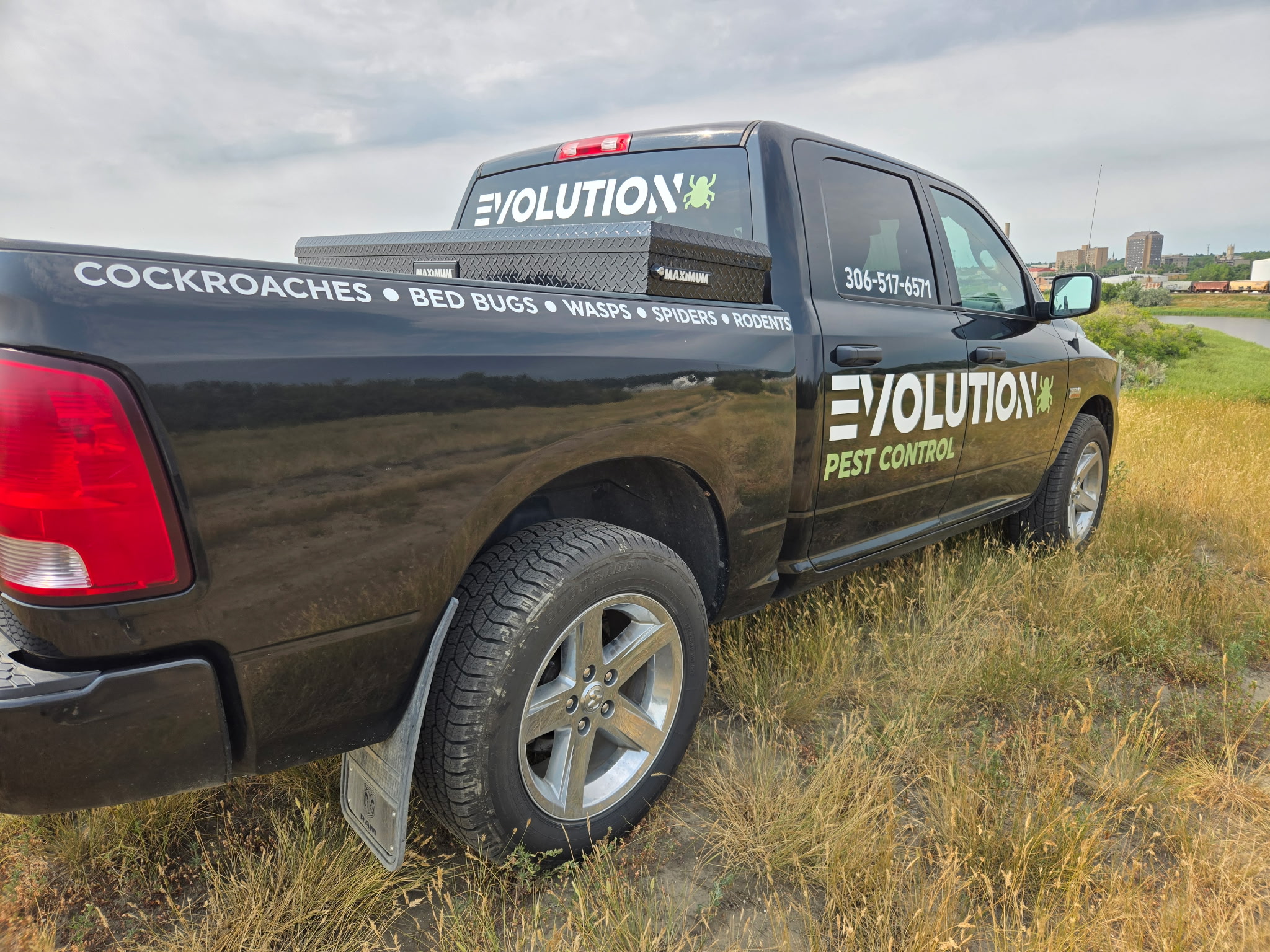 Evolution Pest Control truck with Moose Jaw city skyline in the background
